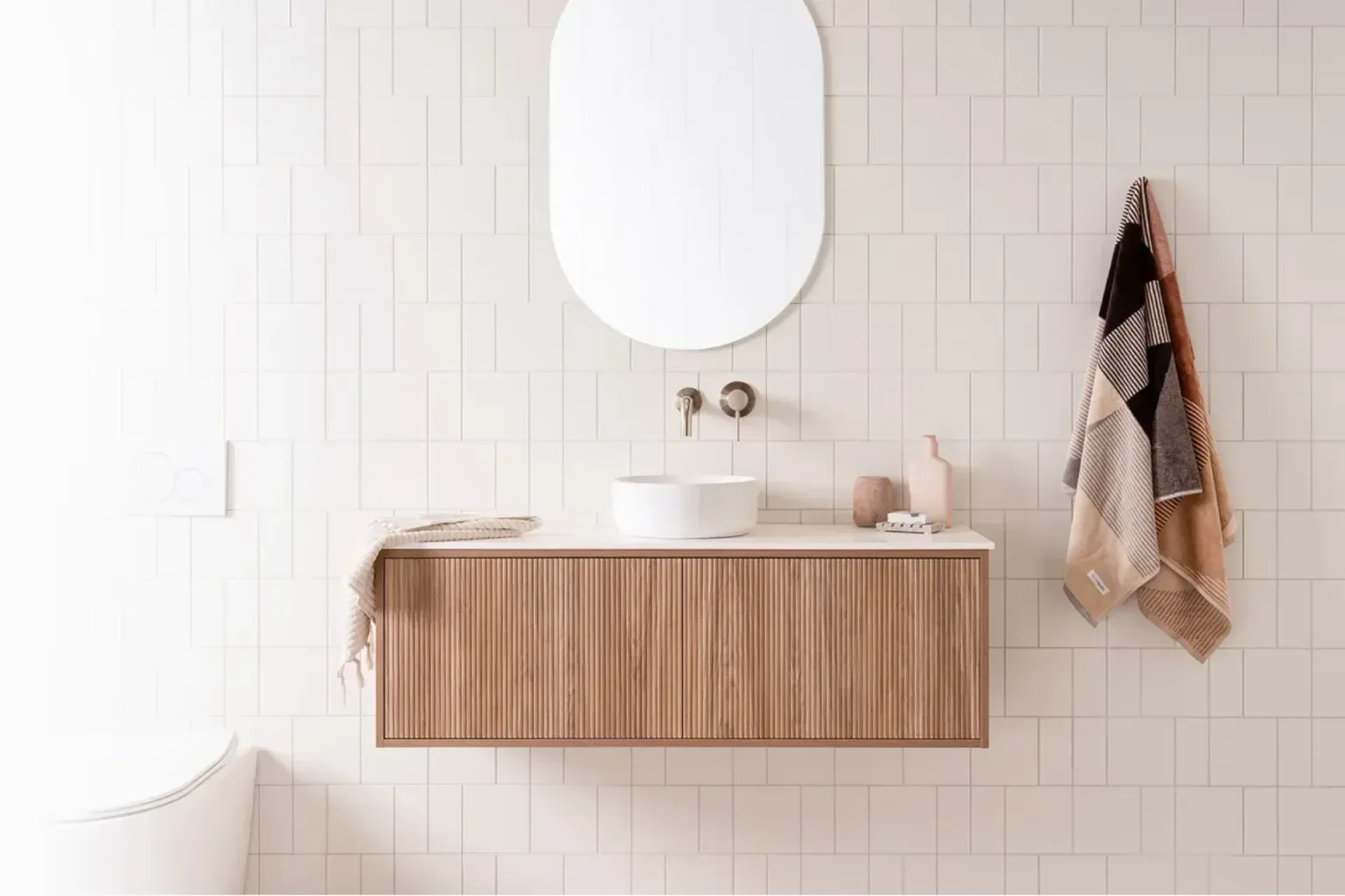 Bathroom remodel wall panels — a tradesperson making a careful final pass over the finished work